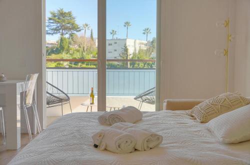 Elle comprend un balcon et un lit blanc avec des serviettes. dans l'établissement studio lumineux refait en 2025 a neuf A0B206, à Cannes