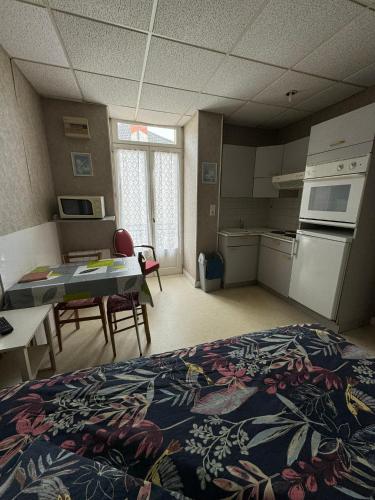 Cette chambre comprend un lit, une cuisine et une table. dans l'établissement Aquanerius Résidence, à Néris-les-Bains