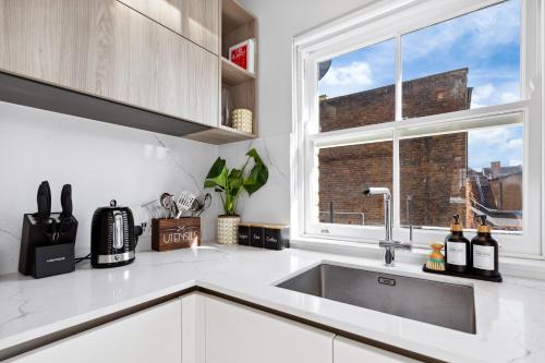 a kitchen with a sink and a window at The Notting Hill Villa in London