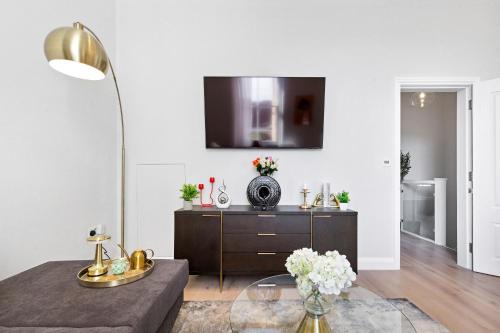 a living room with a table and a tv on a wall at The Notting Hill Villa in London