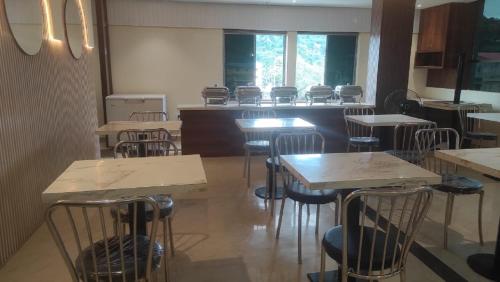 a dining room with tables and chairs in a restaurant at Hotel Hi City Inn Near ISBT in Guwahati