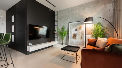 un salon avec un canapé et une télévision dans l'établissement Flatbook - Studio Yacht Park Gdynia, à Gdynia