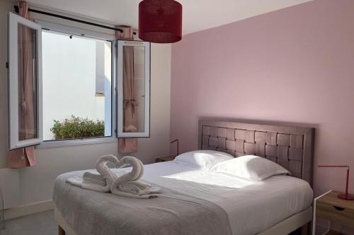 - 2 serviettes de toilette en cygne assises sur un lit dans une chambre dans l'établissement Renovated Villa 2-Min Walk to the Beach, au Bois-Plage-en-Ré