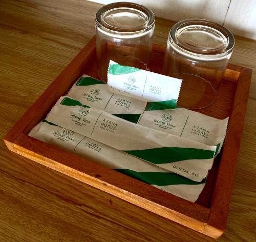 a wooden tray with two jars of honey and labels at Tebing View Glamping, Azana Hotels Collection in Tutugan