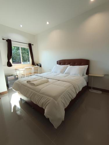 a bedroom with a large bed with white sheets at Good Nine Resort in Ban Lam Kaen