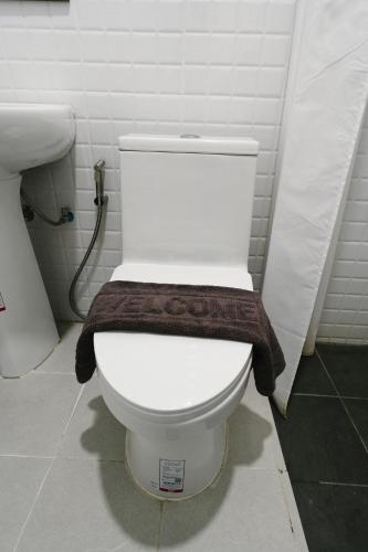 a bathroom with a toilet with a brown towel on it at The Ten Hotel Thippanate in Chiang Mai