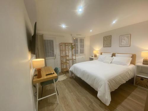 une chambre avec un grand lit blanc et une table dans l'établissement Le Nid'Ophé Studio Cosy - Proche Disneyland Paris, à Mareuil-lès-Meaux