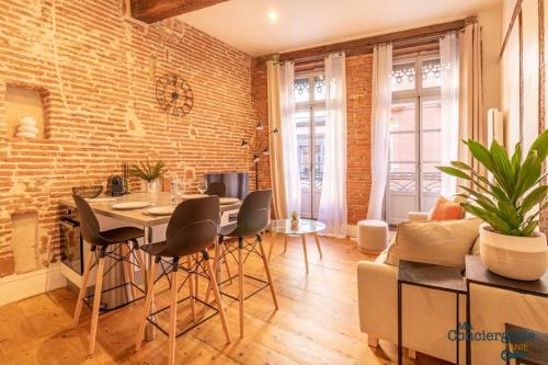 - un salon avec un mur en briques, une table et des chaises dans l'établissement Leon - Capitole - Hypercentre Ville - Métro, à Toulouse