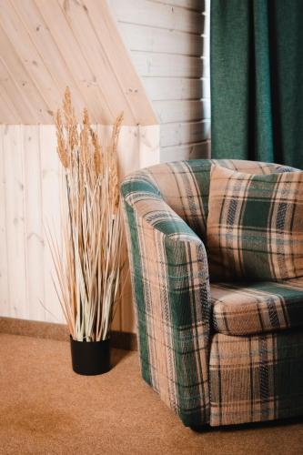 a living room with a plaid chair and potted plants at Porto Resort in Lilaste