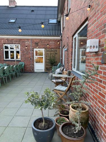 a patio with potted plants on a brick building at Gæstehusets lejlighed in Tarm