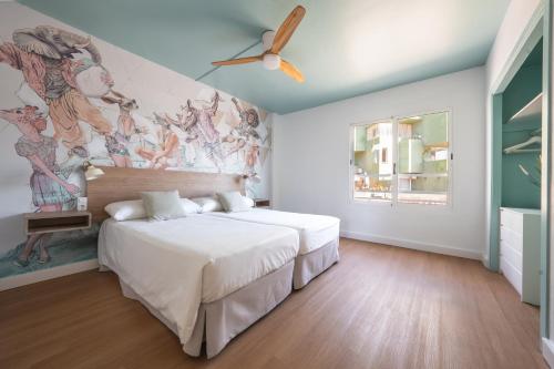 a bedroom with a bed and a painting on the wall at Nura Houses Magaluf Beach in Magaluf