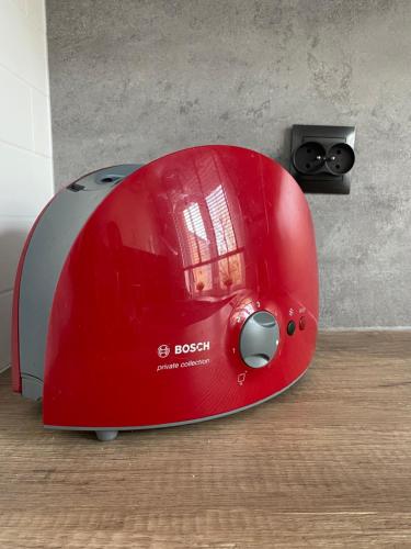 a red toaster sitting on top of a wooden floor at Apartament Starówka in Koszalin
