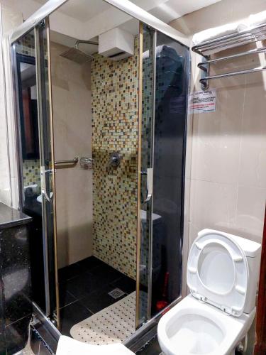 a bathroom with a shower with a toilet in it at Golden Tulip Hotel Port Harcourt -GTPH in Port Harcourt