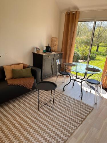 un salon avec un canapé, des chaises et une table dans l'établissement La Sellerie, à Romagné