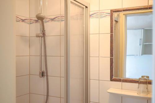 a bathroom with a shower with a mirror and a sink at Hotel Garni Vitamari in Wasserburg am Bodensee