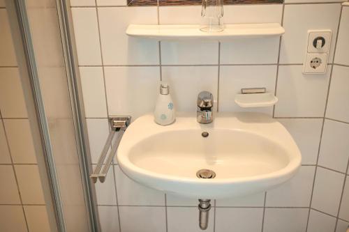 a white sink in a bathroom with a shower at Hotel Garni Vitamari in Wasserburg am Bodensee
