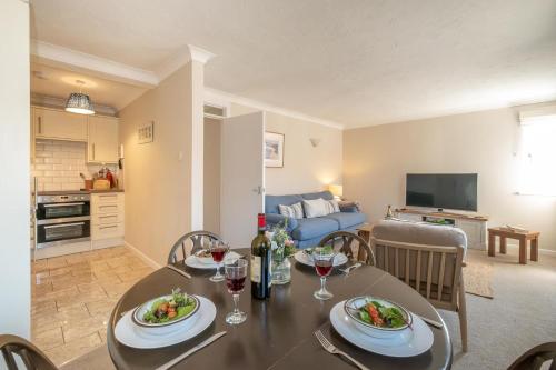 Un comedor y una sala de estar con mesa y sillas. en 3 St Johns Court - Aldeburgh Coastal Cottages, en Aldeburgh