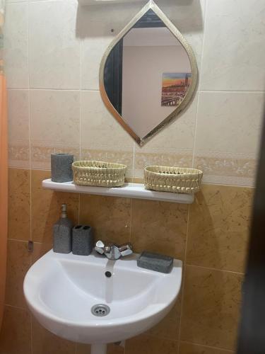 a bathroom with a sink and a mirror on a wall at Riad Nour Resorts-Riad Nour Travel in Marrakech