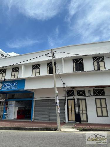 a white building with a pole in front of it at Jomstay Guest House Melaka in Malacca