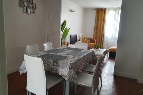 une salle à manger avec une table et des chaises blanches dans l'établissement Bright apartment with nice view, à Boulogne-Billancourt
