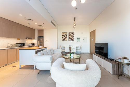 a living room with two chairs and a kitchen at HAVN - 2 Bedroom in Bayshore, Dubai Creek Harbour in Dubai