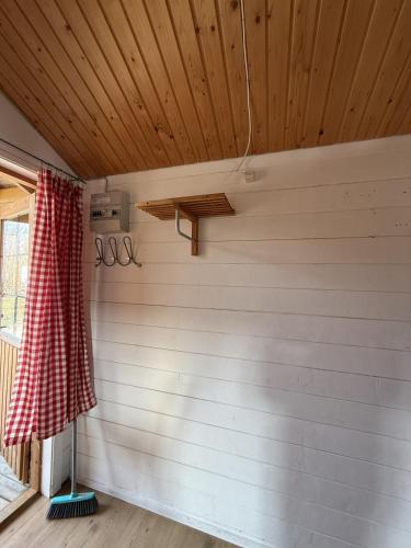 a room with a red checked curtain and a window at Frederiksværk Camping & Hostel in Frederiksværk
