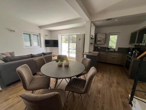 Una sala de estar con una mesa y sillas y un sofá. en Dovolená bez starostí - Apartmány Murter, en Betina