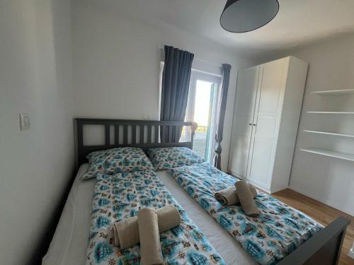 Una cama con dos almohadas encima en un dormitorio. en Dovolená bez starostí - Apartmány Murter, en Betina