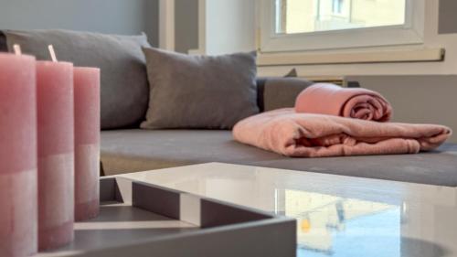 a living room with a couch with a blanket and candles at Na Mijance by LibertaRent in Wałbrzych
