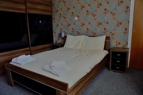 a bedroom with a bed with two towels on it at The Five Bells Inn Accommodation in Claypole