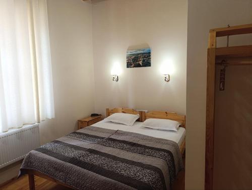 a small bedroom with a bed and a window at Old Town Hotel in Khiva