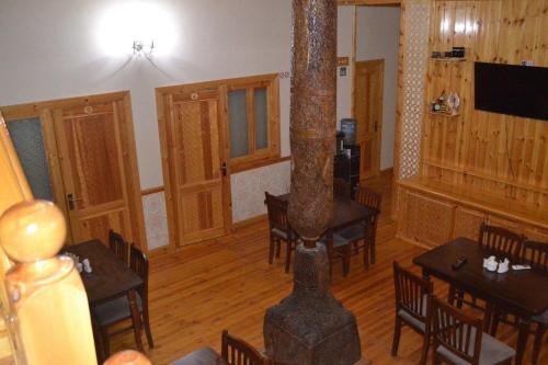 a dining room with tables and a tree in it at Old Town Hotel in Khiva