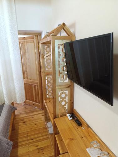 a living room with a television on a wall at Old Town Hotel in Khiva