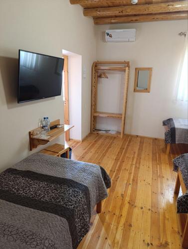 a room with two beds and a flat screen tv at Old Town Hotel in Khiva