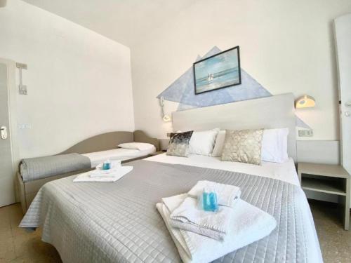 a hotel room with two beds with towels on them at Alevon Hotel in Rimini