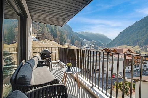balcone con divano, tavolo e vista di Alpine Chic - Fireplace Views & Ski Resorts a See