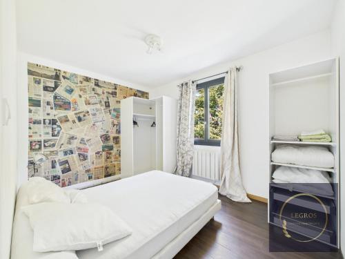 une chambre blanche avec un lit et une fenêtre dans l'établissement Maison des Cigales 8 personnes avec piscine, à Barbentane