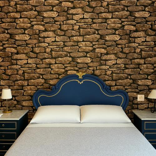 a bedroom with a brick wall with a bed and two tables at Luna de Borobia in Borobia