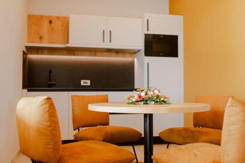 a kitchen with a table with chairs and a microwave at Carolina Luxury Stay in Rogašovci