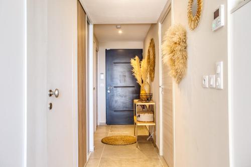 un couloir avec une porte bleue et une chaise dans l'établissement 3 chambres, Vue mer, Piscine, parking, à Sainte-Maxime