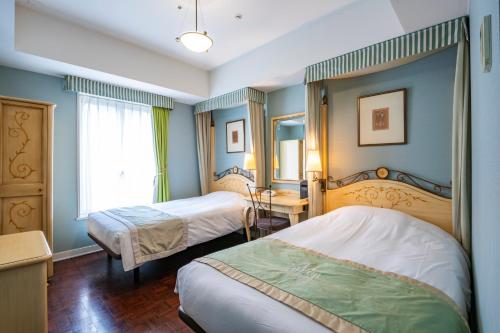 a hotel room with two beds and a window at Hotel Monterey Lasoeur Ginza in Tokyo