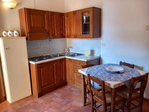 a kitchen with wooden cabinets and a table with chairs at Agriturismo L'Oasi della Pergola in Macchie