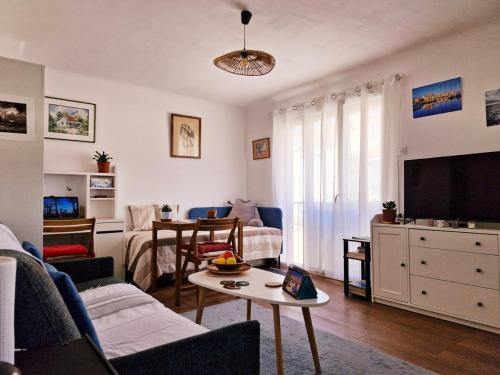 un salon avec un canapé et une table dans l'établissement Cosy T1 proche port La Ciotat, à La Ciotat
