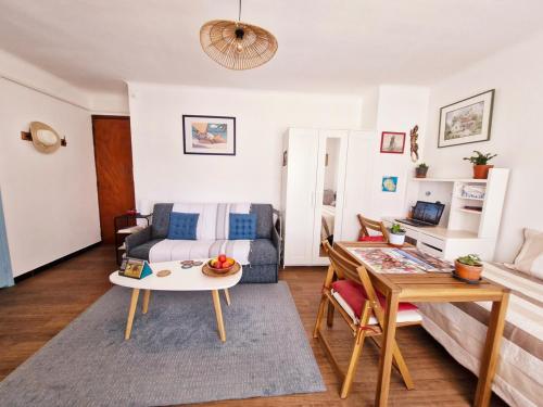 un salon avec un canapé et une table dans l'établissement Cosy T1 proche port La Ciotat, à La Ciotat