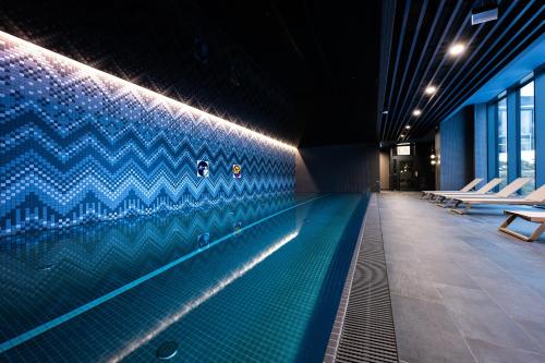 a swimming pool in a building with blue tiles at Mercure Szczyrk Resort in Szczyrk