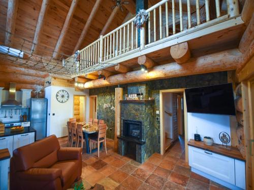 a living room with a kitchen and a dining room at Luxury Log House in Globoko