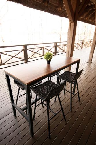 a wooden table and two chairs on a deck at Porto Resort in Lilaste
