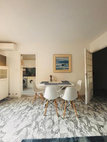 une salle à manger avec une table et des chaises blanches dans l'établissement EMNICE Studio musiciens, à Nice