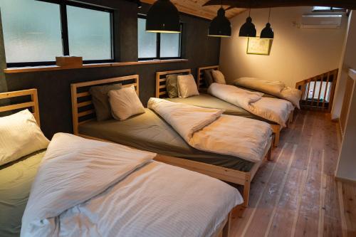 a group of four beds in a room at GOMYO LIFE Hotel in Higashikagawa
