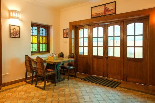a dining room with a table and chairs and a door at Casa Memora 3BHK Private Pool Villa in Saligao